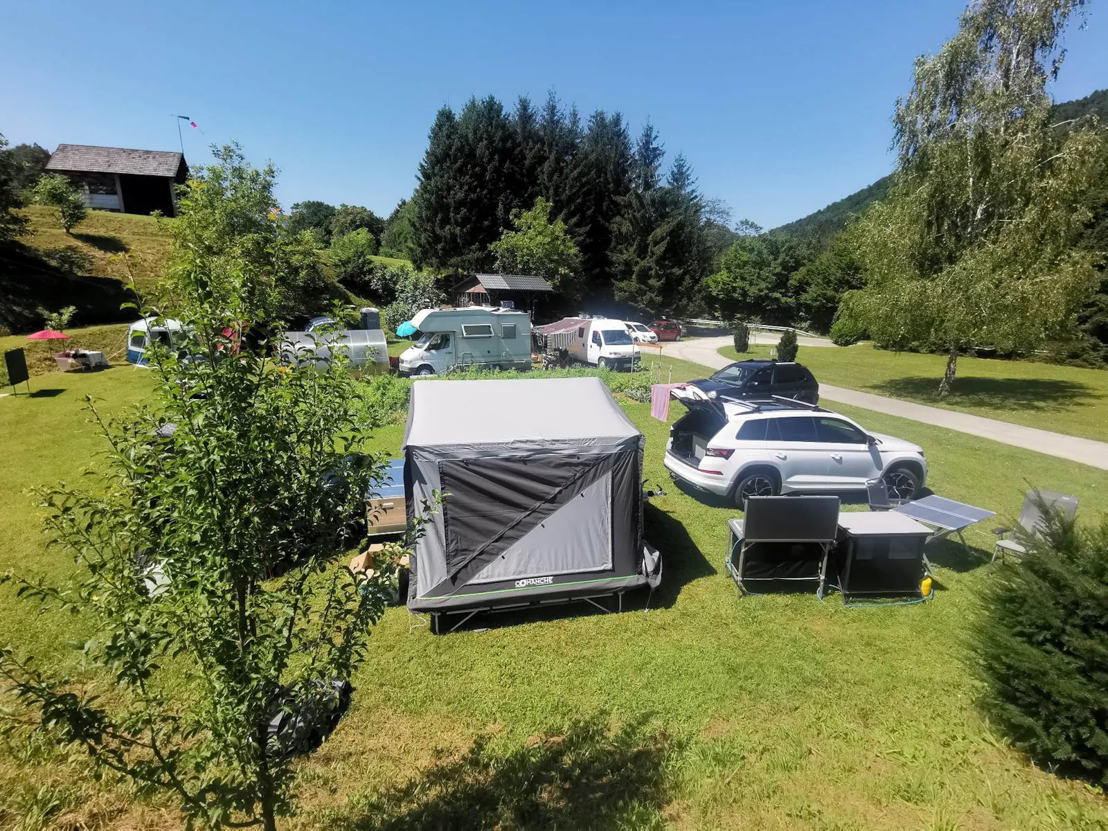 Kamp s šotori in avtodomi na travniku ob Krki
