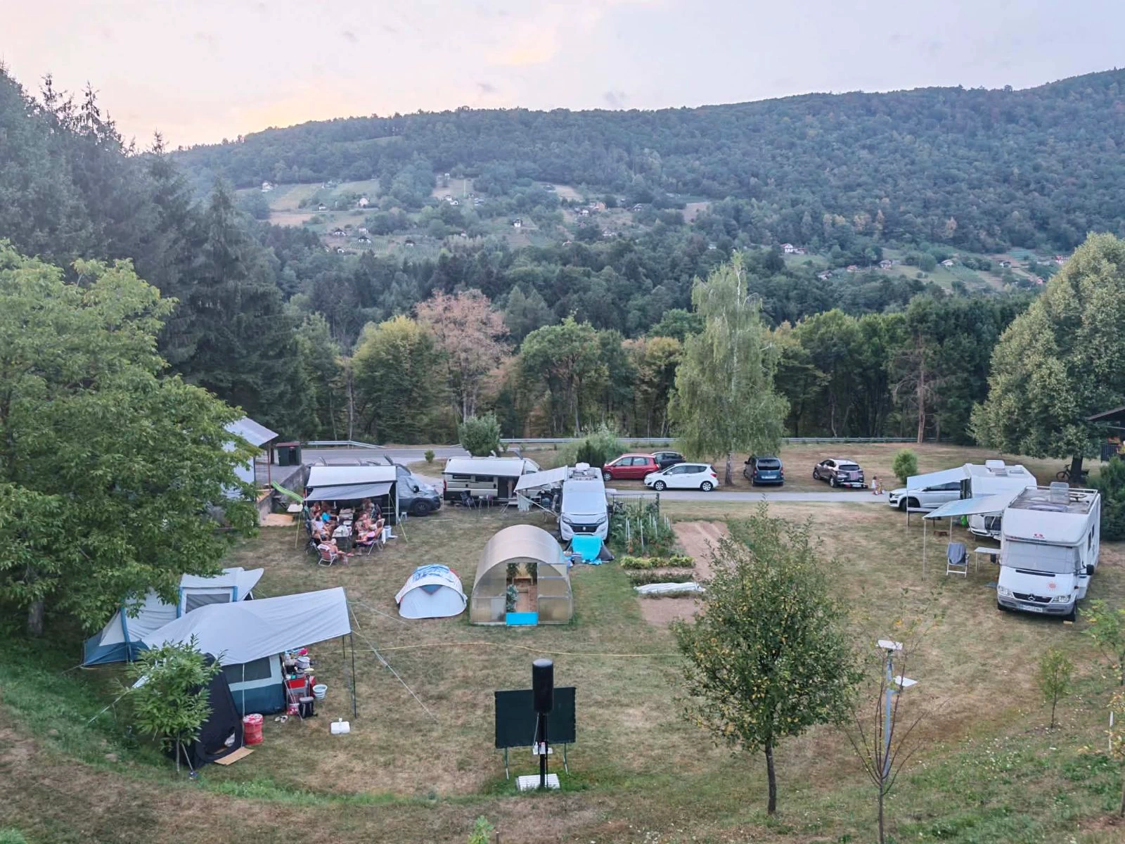 Pogled od zgoraj na tabor s šotori, prikolicami in avtodomi na posesti ob Krki v Rumanji vasi
